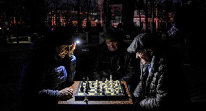 Чоловіки грають у шахи в столичному Парку Шевченка під час блекаутів 2022/2023 року /Getty Images
